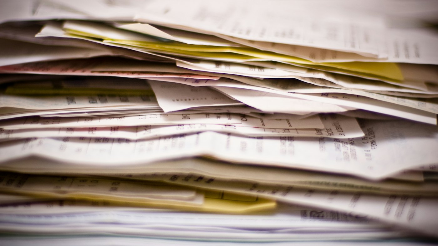 Pila de facturas y comprobantes en papel sobre un escritorio